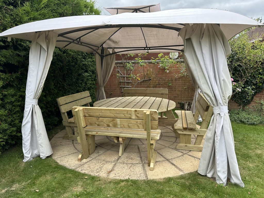 large 12 seater round picnic table with backs on the chairs