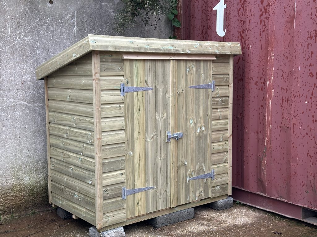 small delivery shed with double doors on the front of it.